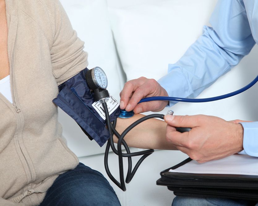Eine medizinische Fachkraft misst den Blutdruck eines Patienten